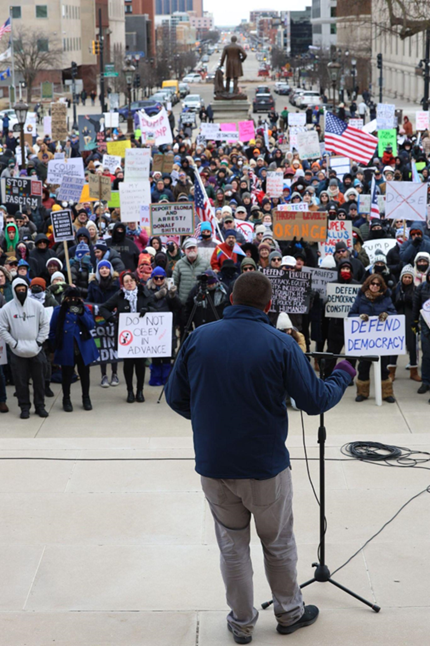 Michigan State Representative Dylan Wegela speaks to the crowd at a protest.