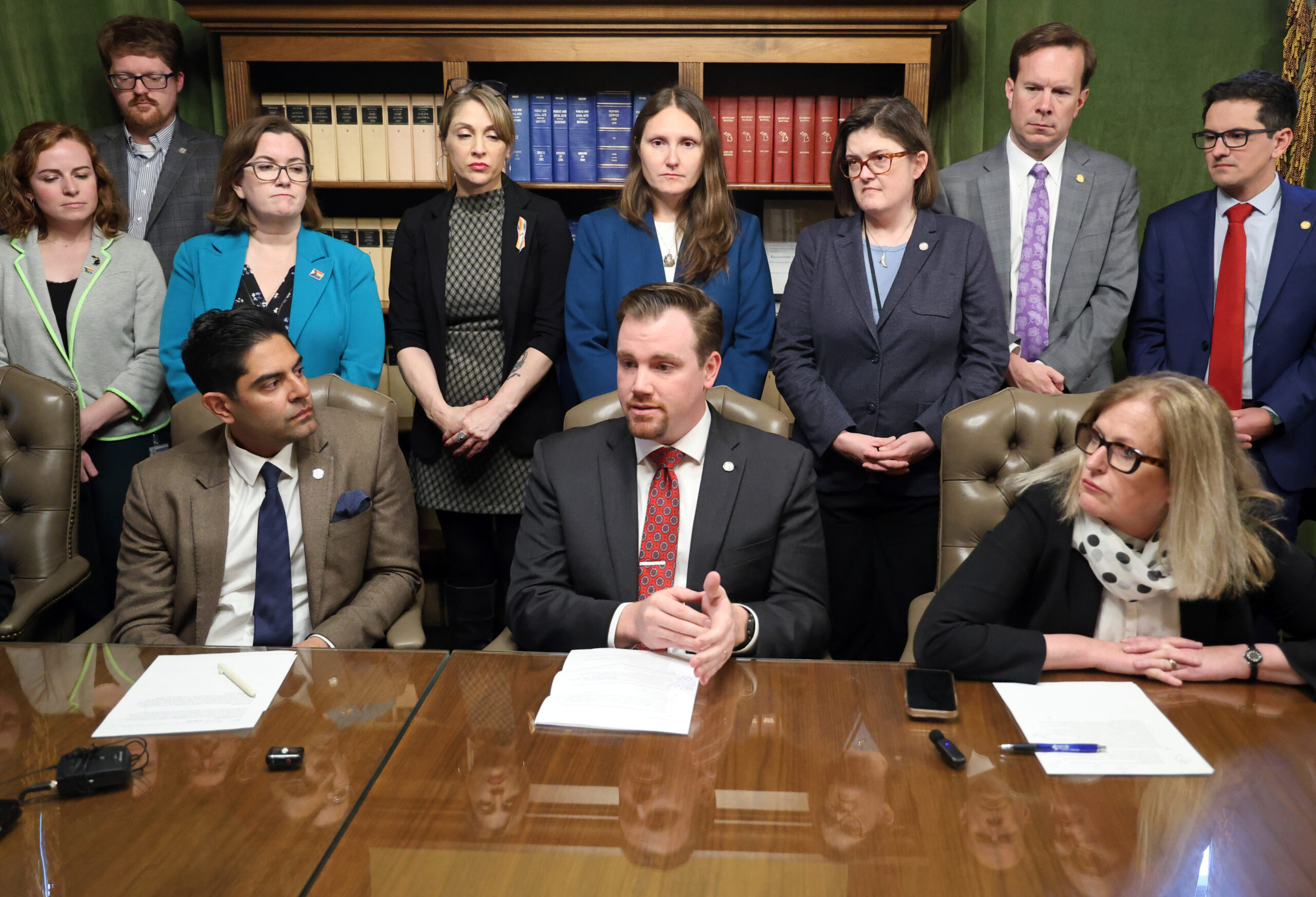 Michigan state Representative John Fitzgerald sitting between House Democrats while speaking with the press.