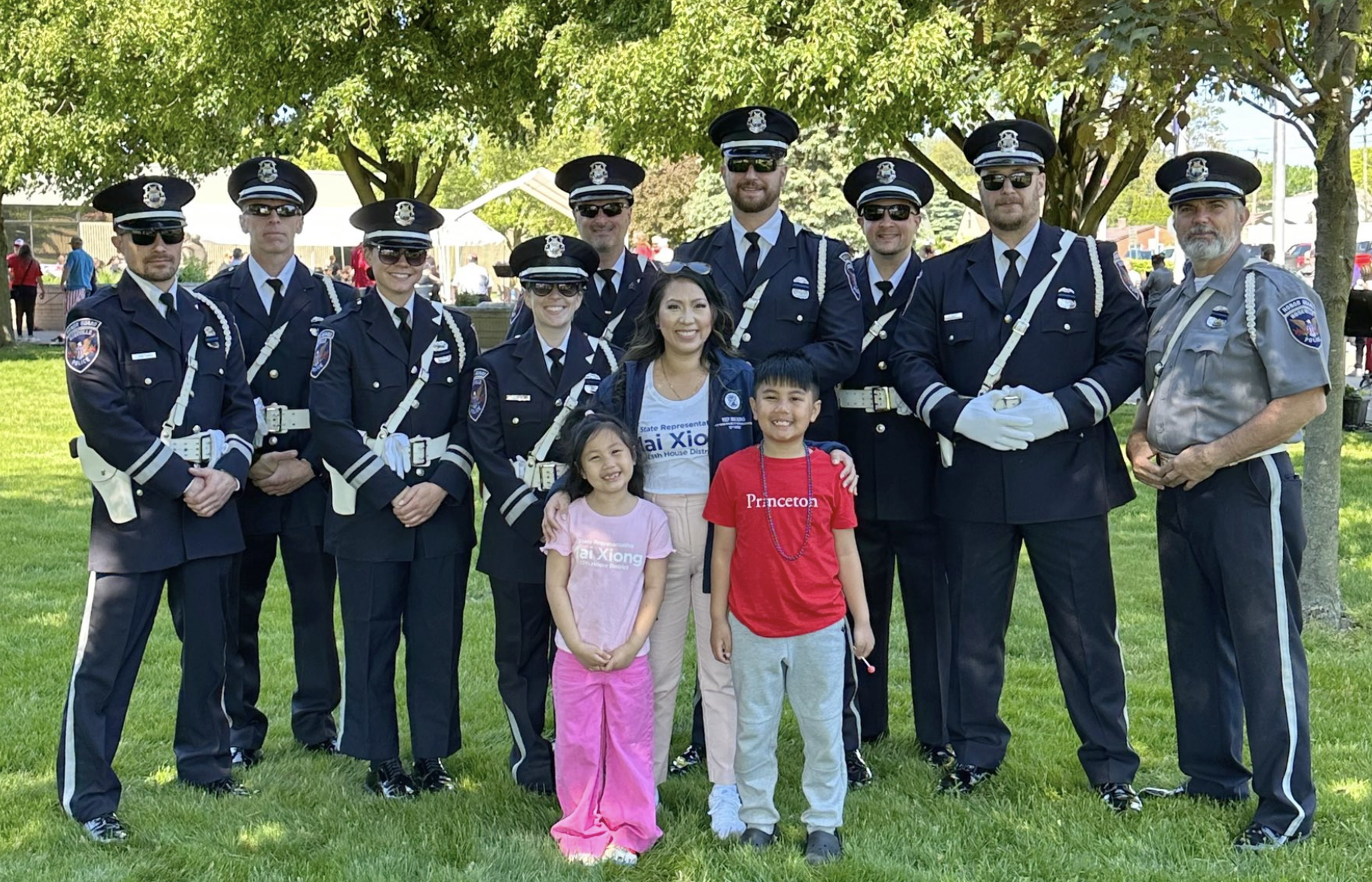 Michigan state Representative Mai Xiong and her kids posing for a photo with officers at a Memorial Day event.