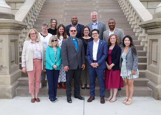 Members of the Public Transit Caucus stand together at the steps of the Capitol building in Lansing.