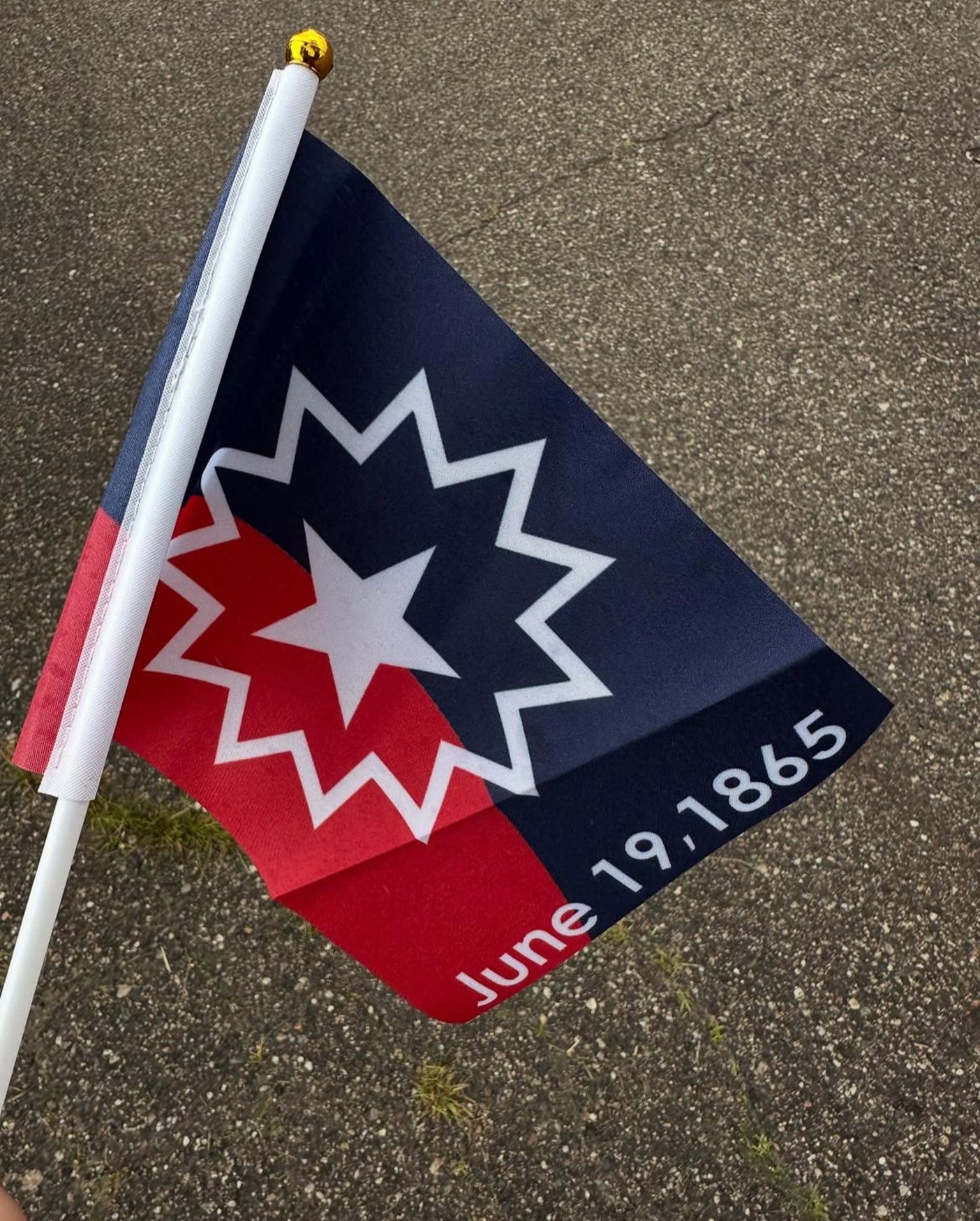 red and blue flag with a star within a star, below is text that reads: June 19, 1865