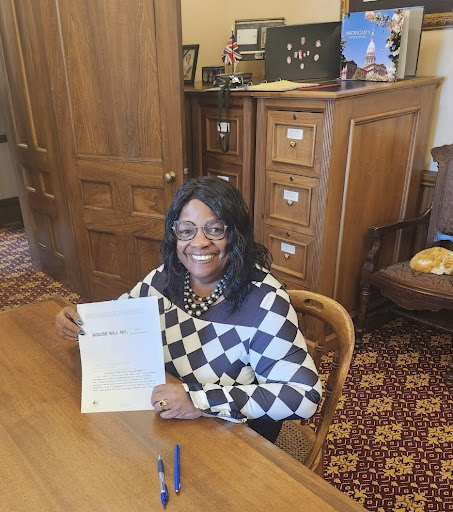 State Rep. Brenda Carter holding HB 4675 at the Capitol building in Lansing.