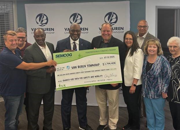 Michigan state Representative Reggie Miller presenting a large check with members of the Southeast Michigan Council of Governments to representatives of Van Buren Township.