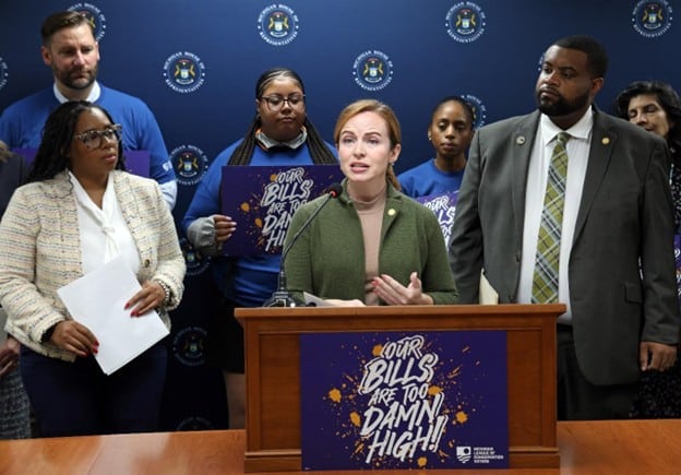 State Rep. Erin Byrnes speaks at “Our Bills Are Too Damn High” Press Conference with Representatives Kristian Grant (left) and Donavan McKinney (right) and other advocates
