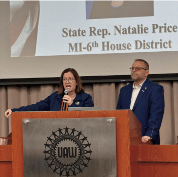 State Rep. Price (left) stands speaking alongside state Rep. Mike McFall (right) at the UAW CAP Conference.