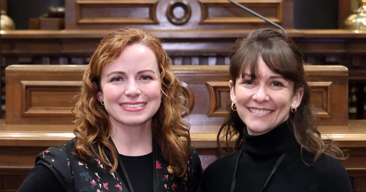 State Rep. Erin Byrnes (D-Dearborn) standing with her guest at the State of the State address on Wednesday, Feb. 25, 2026 on the House Floor at the Capitol Building in Lansing.