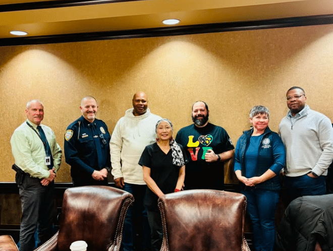 State Rep. Betsy Coffia, second to right, along with Grand Traverse County Sheriff Mike Shea, Traverse City Police Chief Matt Richmond, E3 Council members Chris Stone, Amy Yee, Marco Cabrera, and Marshall Collins. E3 Council member also present but not pictured is Reverend Dr. Wendy von Courter.