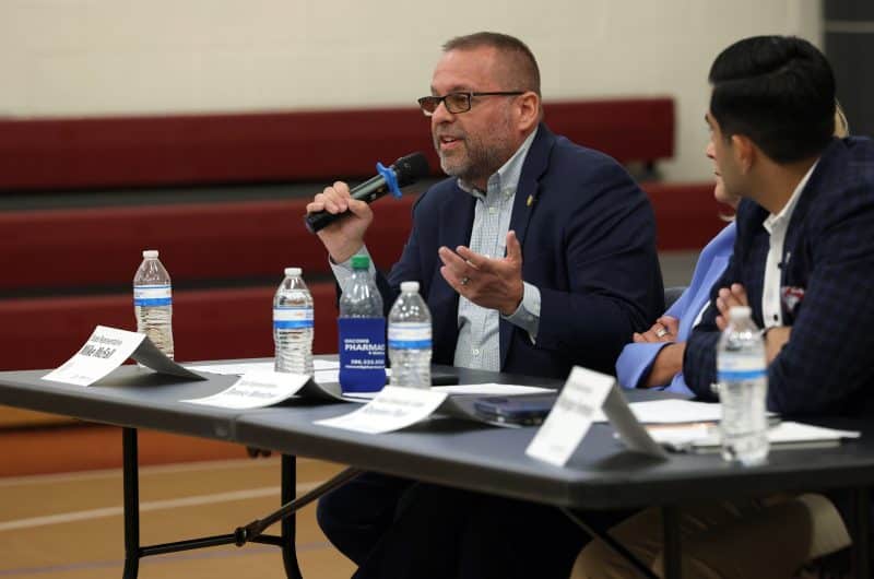 Photo of a sitting Rep. McFall speaking into a microphone at a Vision for Michigan town hall event.
