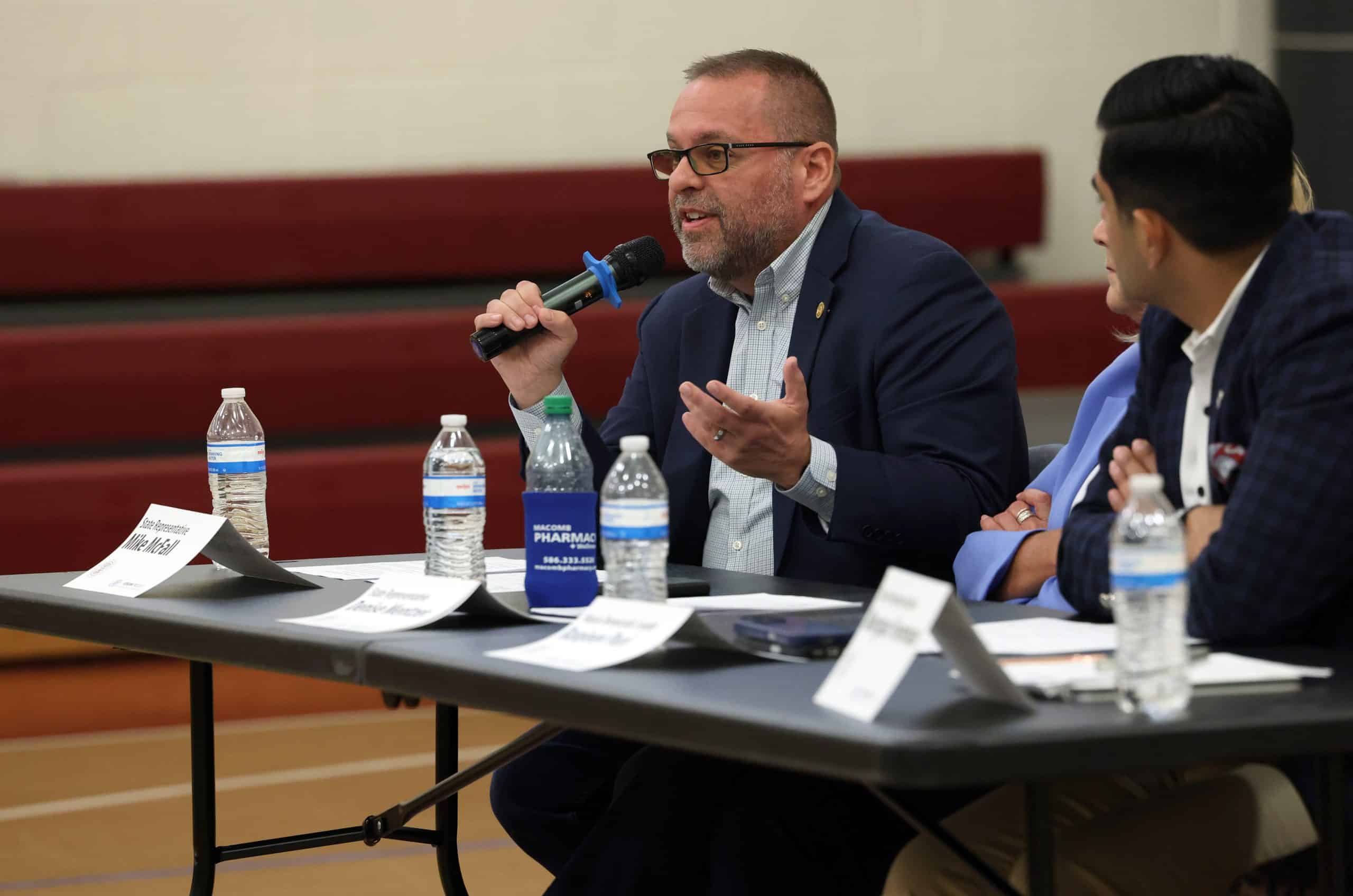 Photo of a sitting Rep. McFall speaking into a microphone at a Vision for Michigan town hall event.